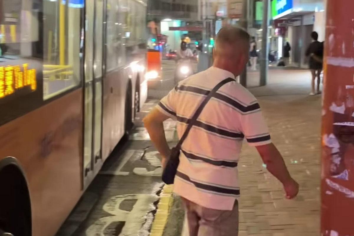 鰂魚涌惠安苑巴士站有巴士疑被私家車阻礙埋站,一名中年漢落車後多番折返及指罵車長「×你老×」。(網民Anson Lau影片截圖@FB群組「車cam L(香港群組)」)