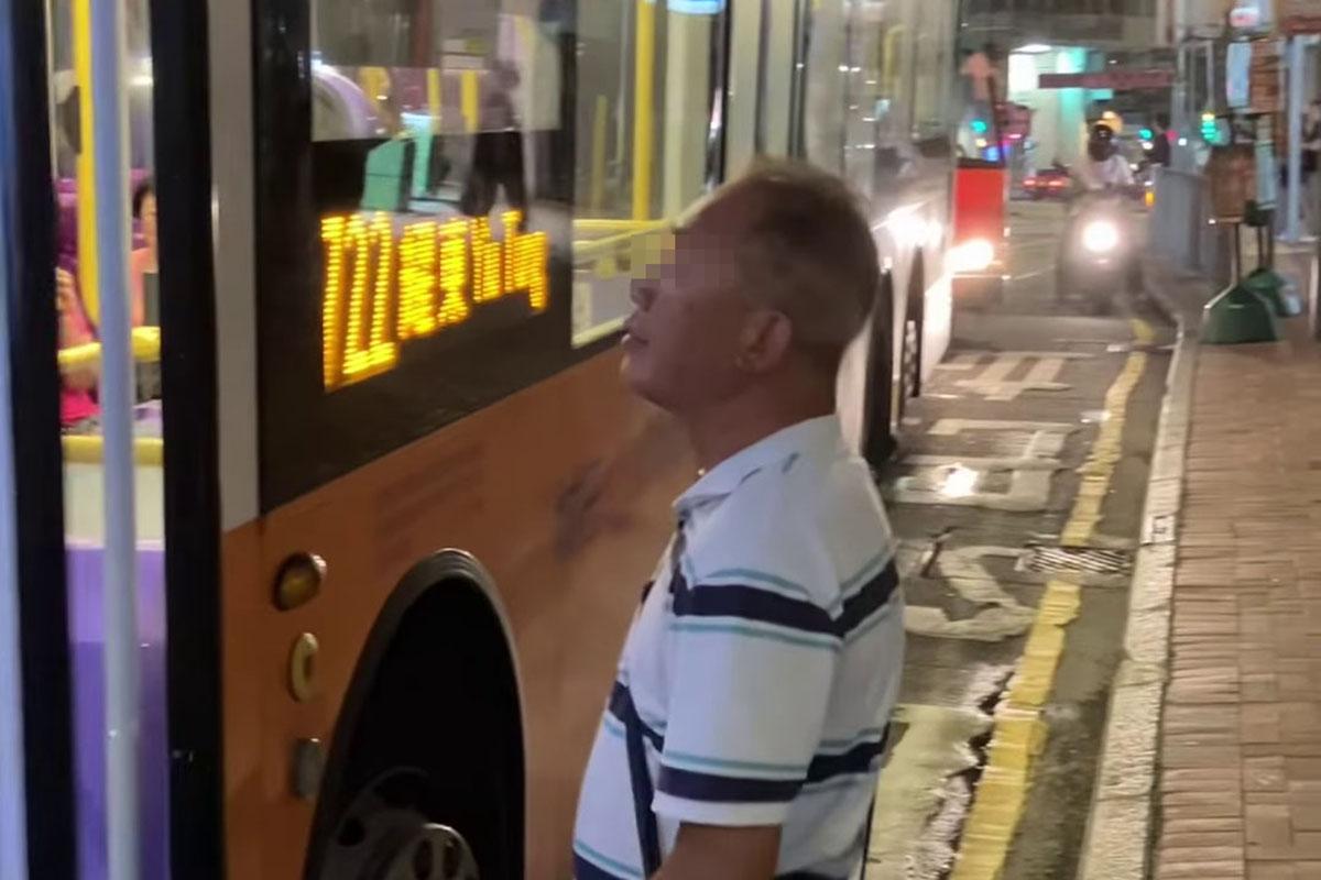 鰂魚涌惠安苑巴士站有巴士疑被私家車阻礙埋站,一名中年漢落車後多番折返及指罵車長「×你老×」。(網民Anson Lau影片截圖@FB群組「車cam L(香港群組)」)