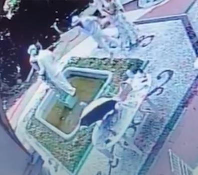 一對男女抱着雕像拍照。(影片截圖)