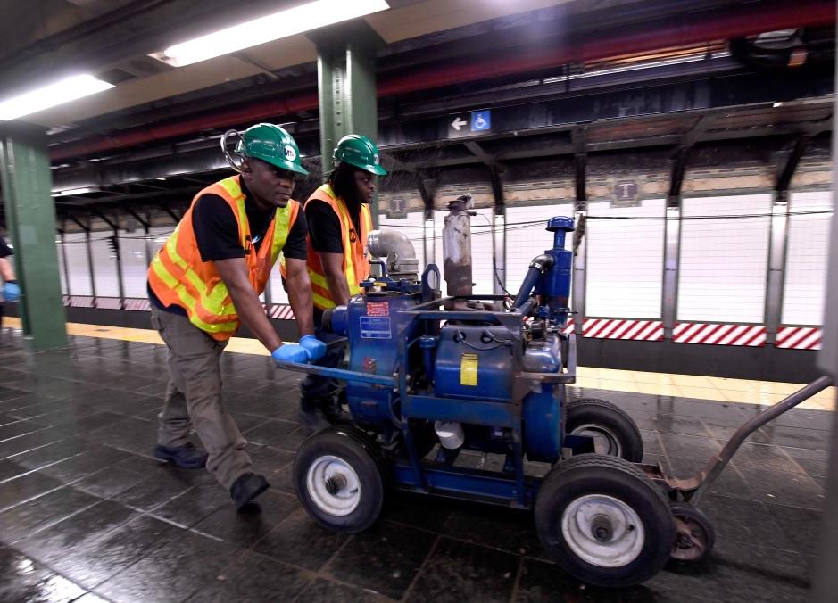 工人用水泵抽走積水。(互聯網)