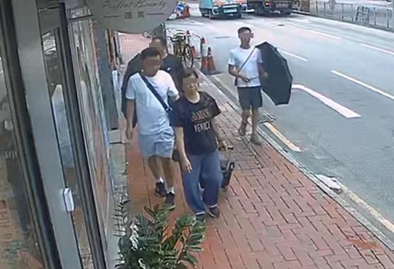 一名拖購物車孭背嚢的女子,沿荃灣沙咀道步行,後方遭3名男子以「品」字形緊隨。(西環變幻時@FB)