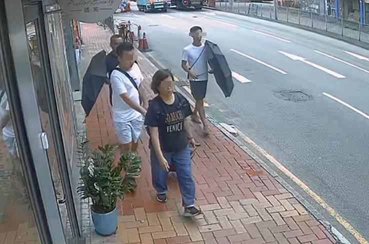較前方男子多次伸手入女子背嚢,稍後方的兩名男子一左一右打開雨傘疑似為落手男子掩護。(西環變幻時@FB)