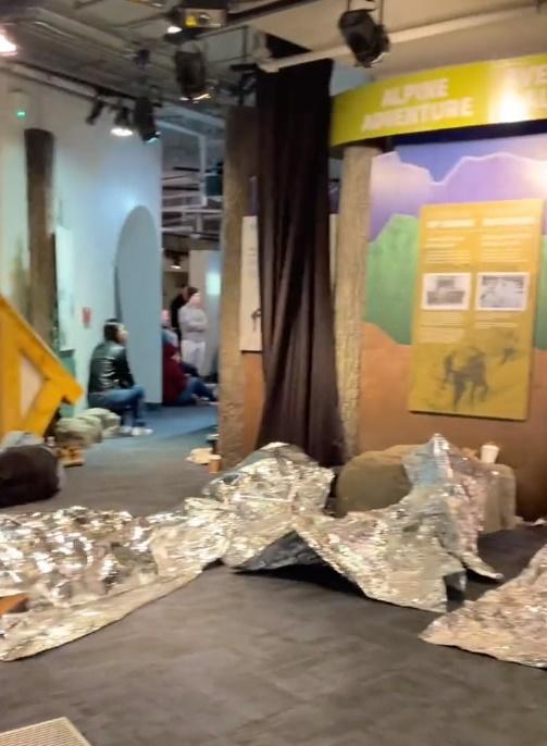 多名遊客蜷縮在應急用的銀色氈子內、睡在地板上過夜。(X)