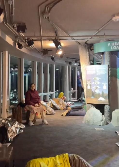 多名遊客蜷縮在應急用的銀色氈子內、睡在地板上過夜。(X)