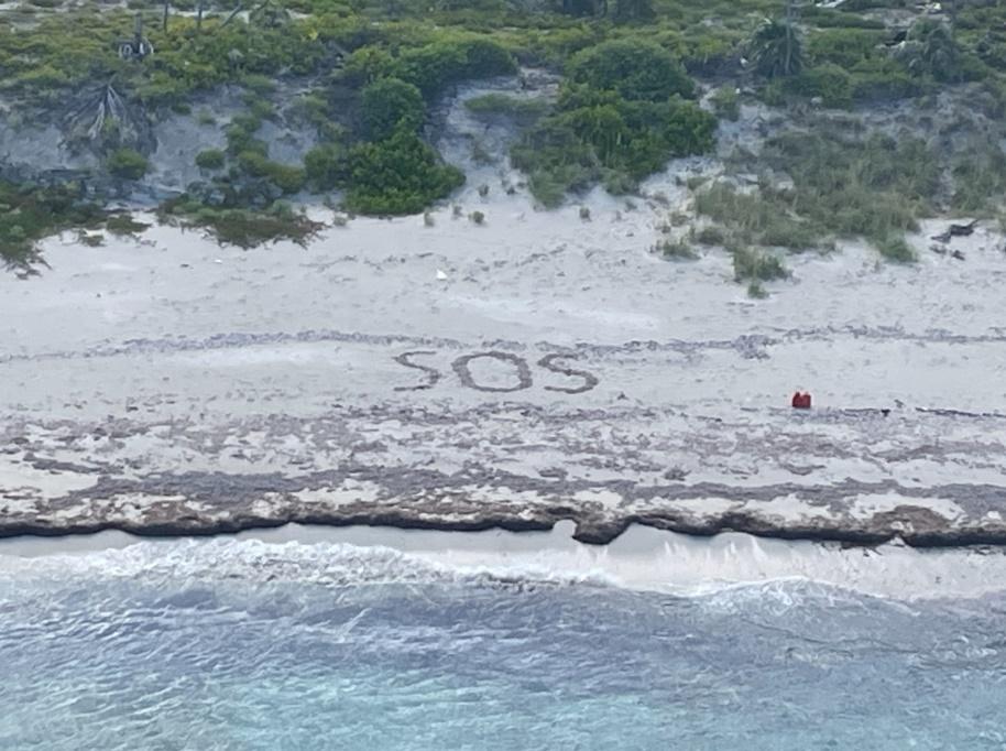 沙灘寫有「SOS」的求救訊號。(FB)