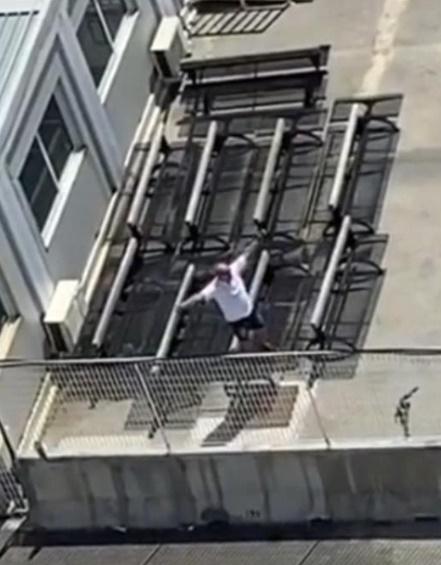 白衣男子一邊喊,一邊站往高處向郵輪高舉雙手揮動,希望可以被看見。(TikTok)