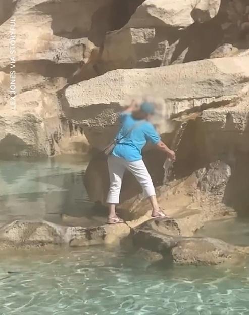 她攀爬著噴泉的石壁,用手上的水樽從噴泉口中裝了一樽泉水。(X)