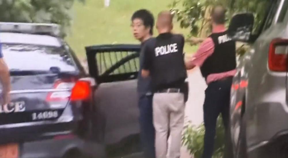 多名警員將一名身穿衣服的男子押解上車。(X)