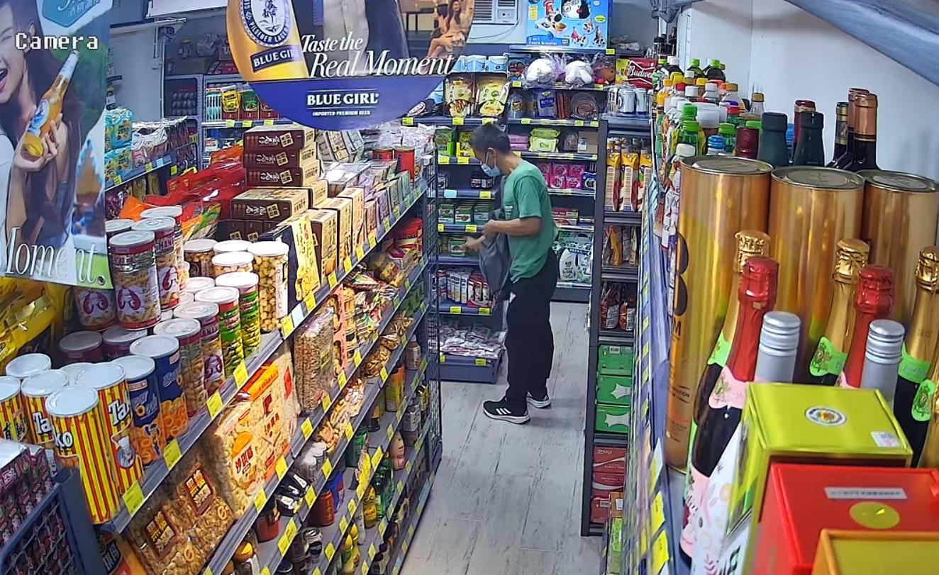 男子不斷將貨架上的罐頭放入背囊。(網上截圖)