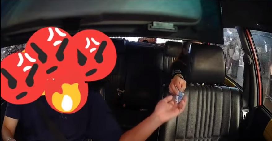 女乘客將上衣內取出的錢付款給司機。