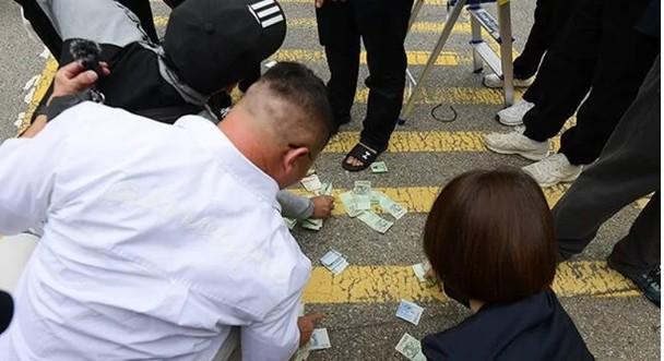 劉亞仁乘坐車輛離去後,有人上前把地上紙幣拾起。