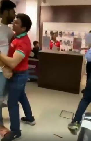 白衣男扯火,旁人阻止。(互聯網)