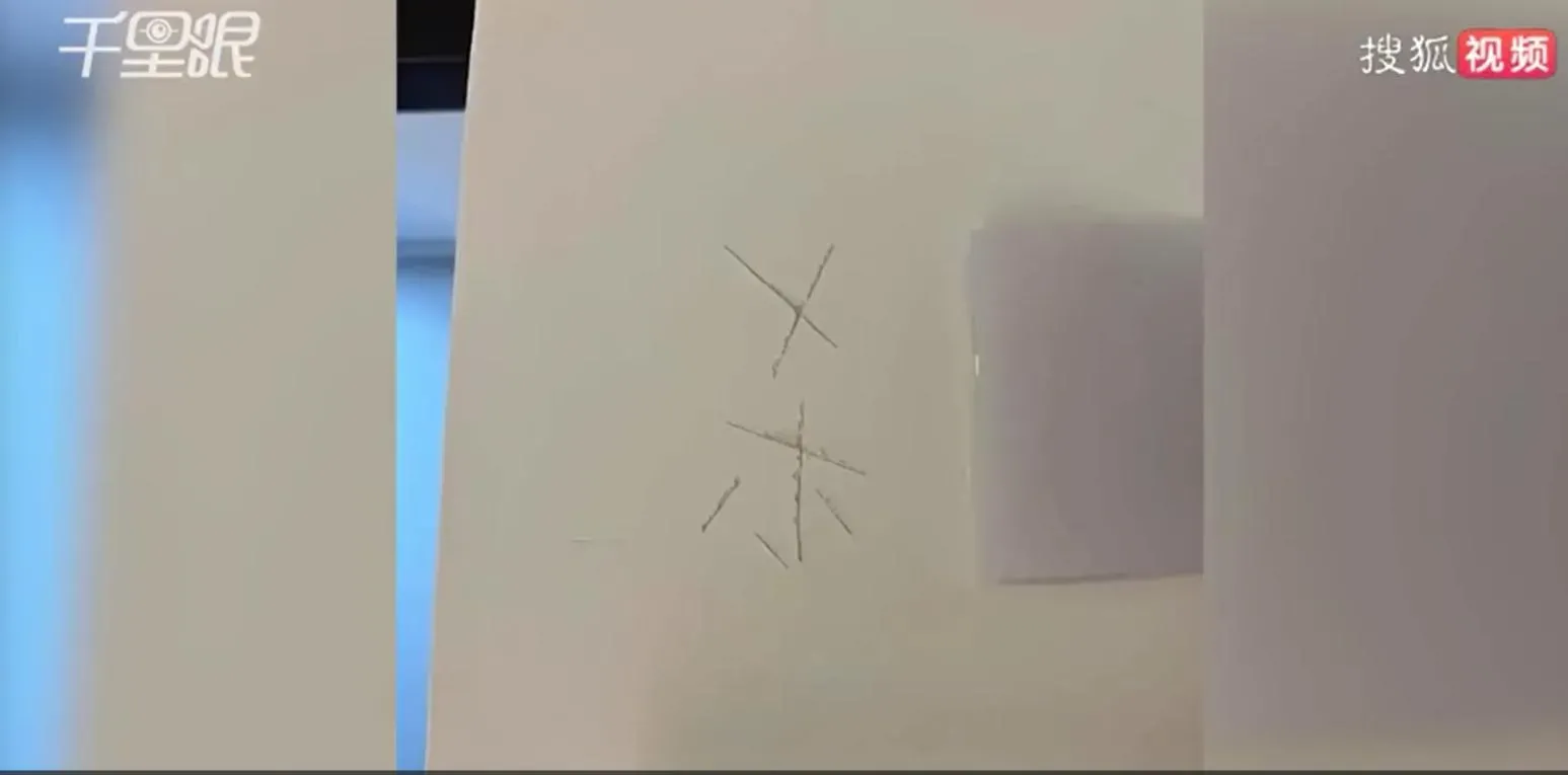 女子用刀在牆上刻出「殺」字。(圖/翻攝搜狐千里眼)