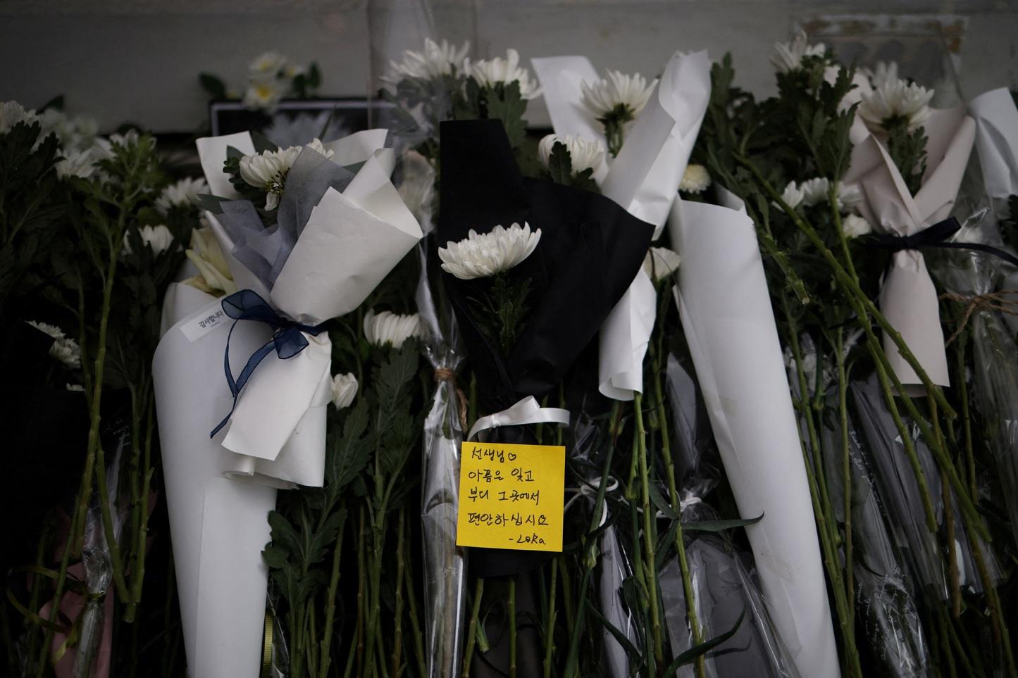 南韓一名教師疑不堪壓力自殺,民眾周一在首爾集會悼念及抗議。(路透社)