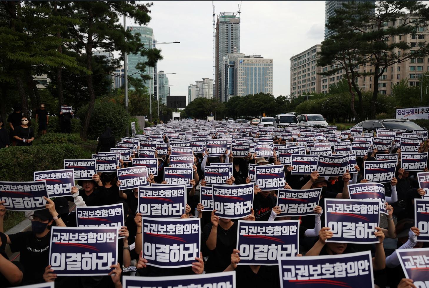 南韓一名教師疑不堪壓力自殺,民眾周一在首爾集會悼念及抗議。(路透社)