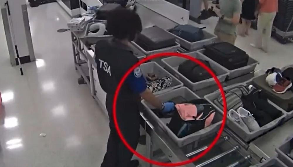 職員偷偷打開旅客行李偷竊。(影片截圖)