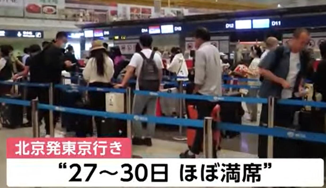 北京機場不少遊客在往日本的櫃檯前排隊。(新聞截圖)