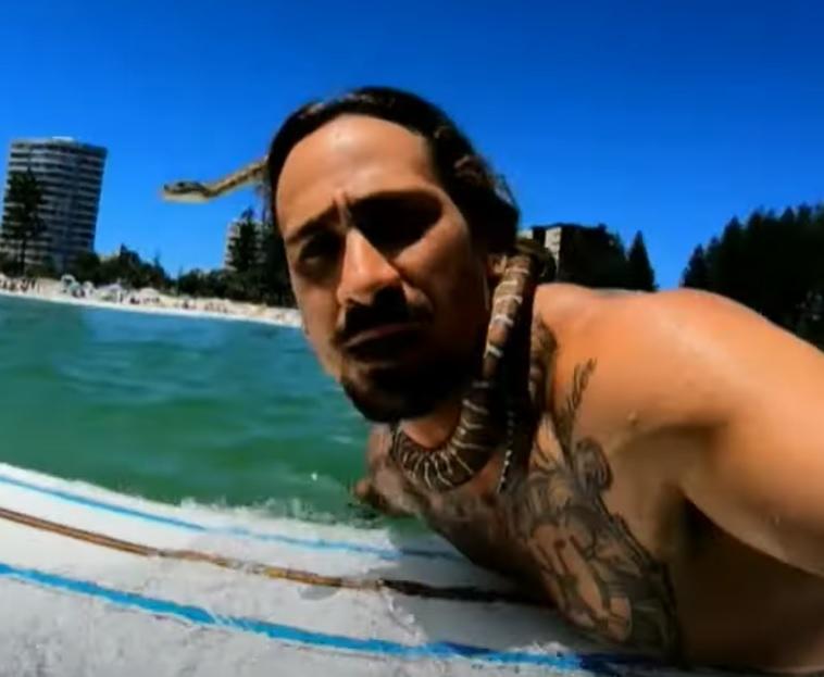 澳洲男子帶寵物蛇滑浪被罰款。(影片截圖)