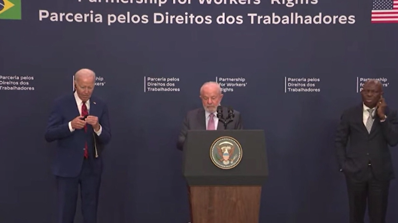 拜登出醜|盧拉開始講話時,拜登低頭不斷解耳機線。(互聯網)