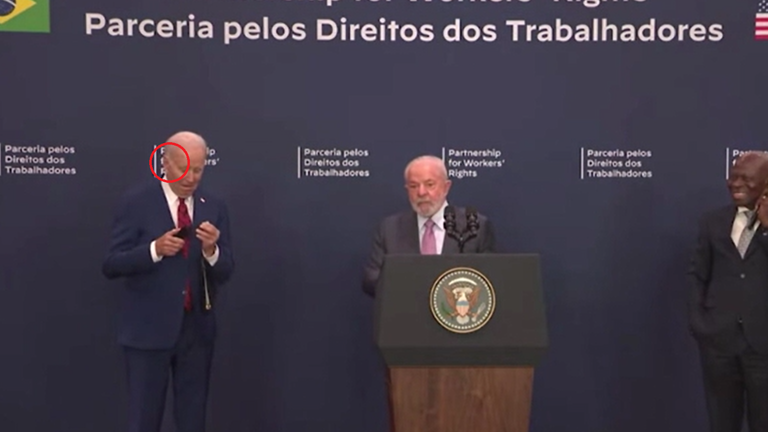 拜登出醜|盧拉講話時,拜登耳機鬆脫,他隨即流露茫然表情。(互聯網)