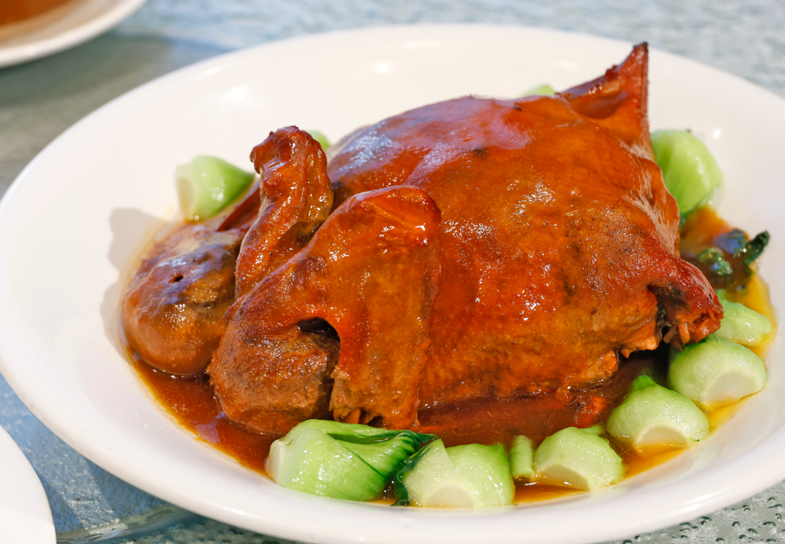 八寶鴨要先去骨刷醬風乾後,釀入蛋黃、蓮子、黑豆等八種配料後再炸後蒸,最後更要淋上汁醬。(攝:林俊源)