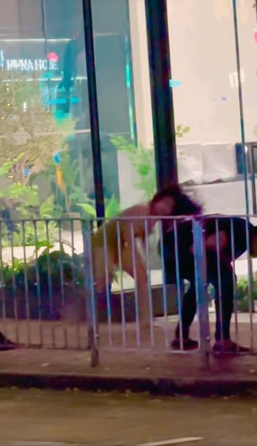 短裙女子拾起地上的雜物擲向黑衣男子。(網片截圖)