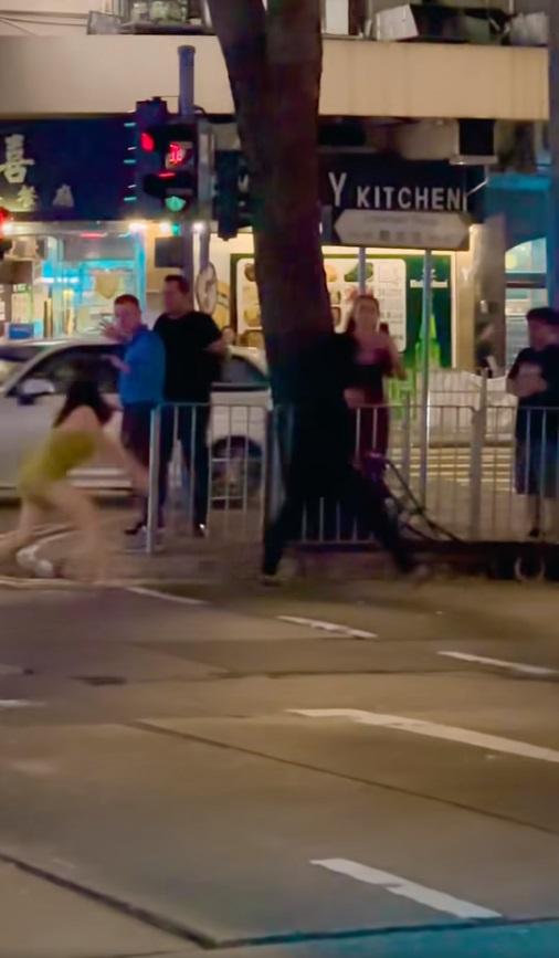 短裙女子拿出掃把打向壯漢。(網片截圖)