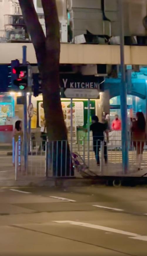 短裙女子與黑衣男子在馬路上對峙。(網片截圖)