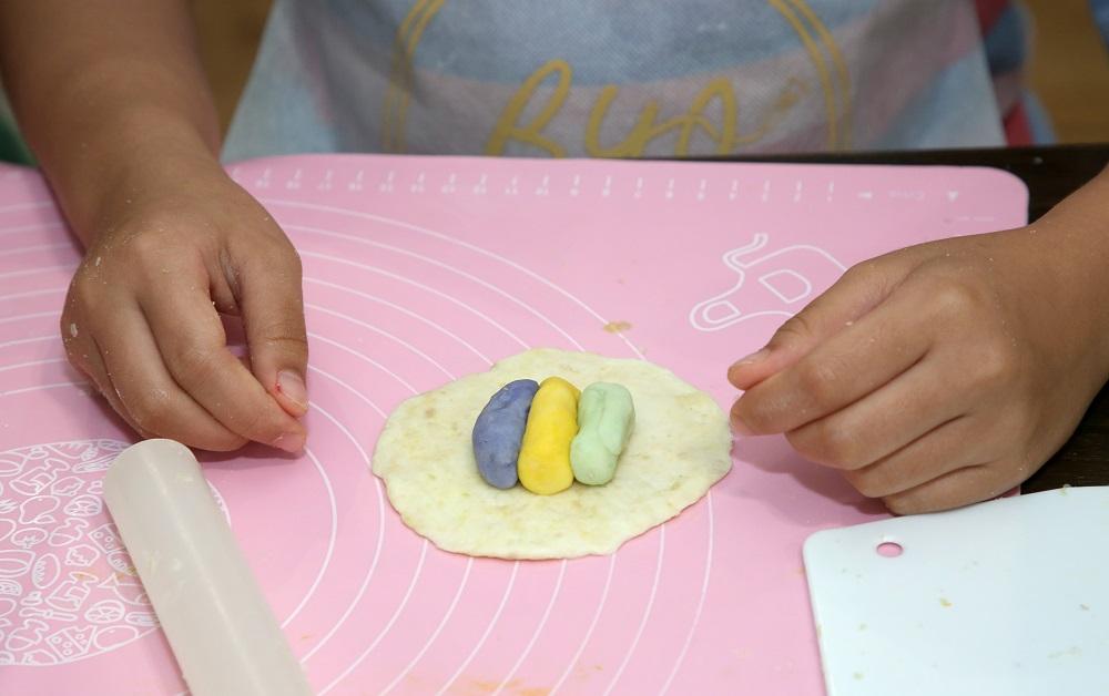 將水皮捏成圓盤狀,再將三色油皮略為搓成條狀,並排放在水皮中心。