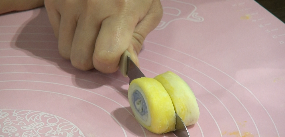 在中間切開一刀切下一半,不要拖刀。完成後放在一旁蓋著備用。