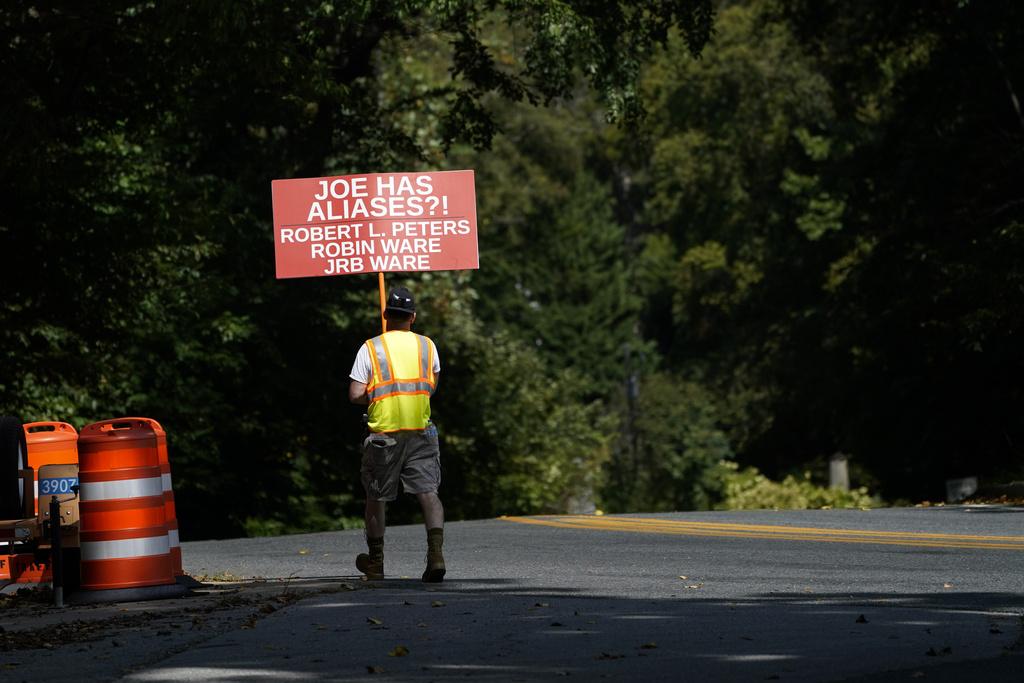 有民眾在拜登的特拉華州寓所外舉牌抗議。(美聯社)