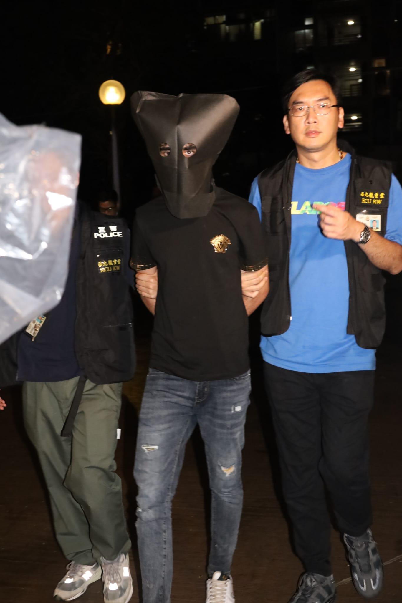 疑犯黑布蒙頭,被警員押返黃大仙竹園北邨桐園樓住所搜查。 (鍾式明攝)