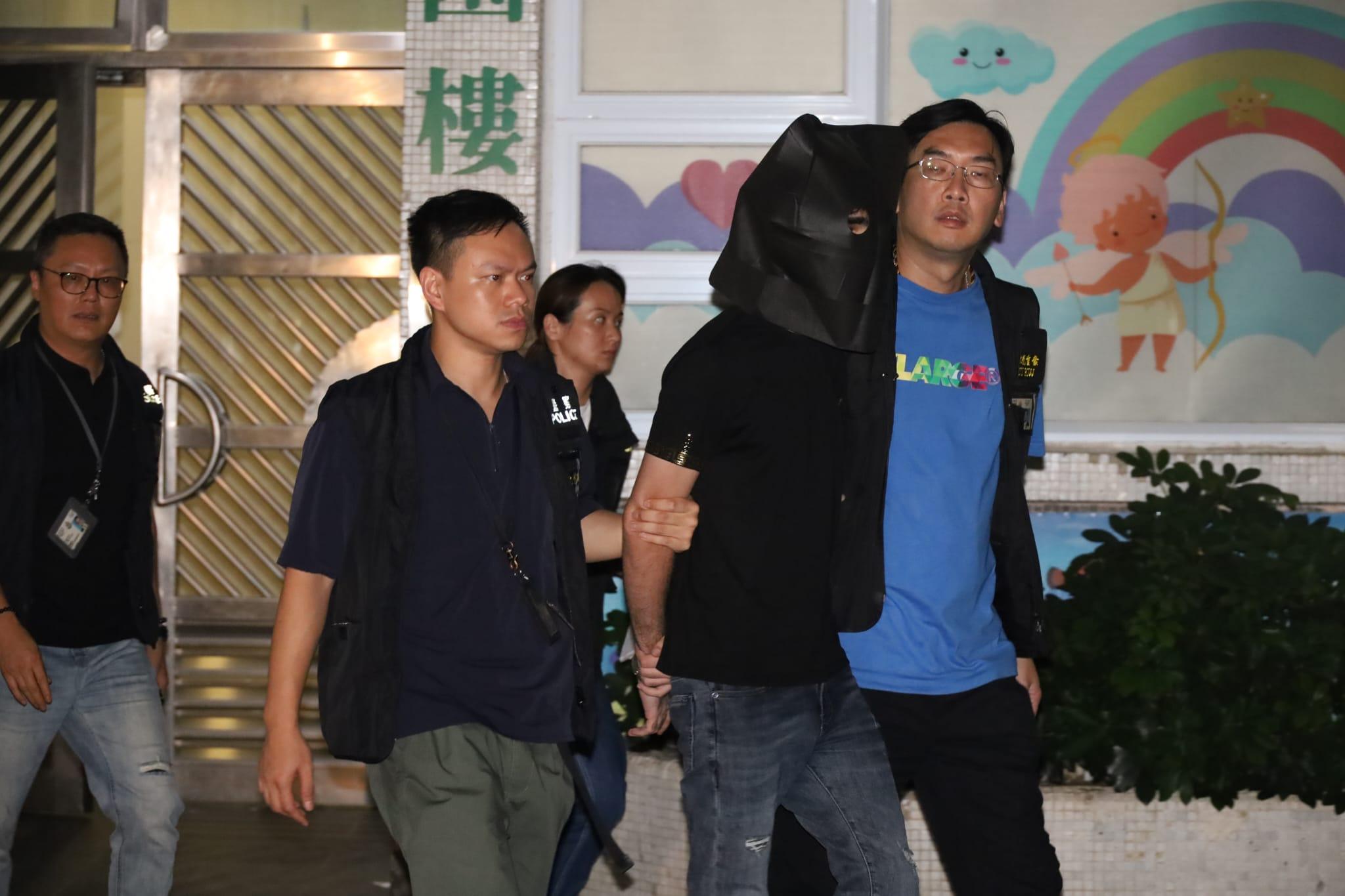 疑犯黑布蒙頭,被警員押返黃大仙竹園北邨桐園樓住所搜查。 (鍾式明攝)