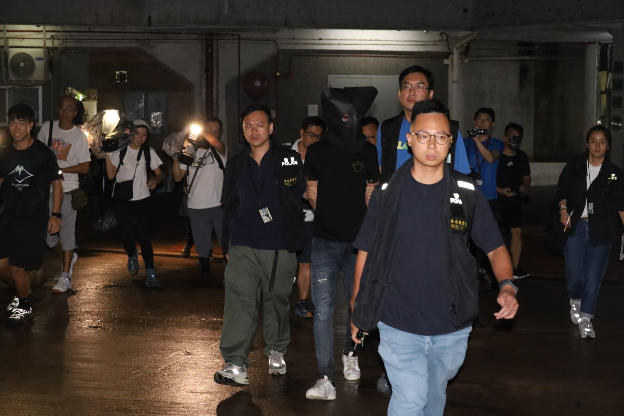 疑犯黑布蒙頭,被警員押返黃大仙竹園北邨桐園樓住所搜查。 (鍾式明攝)