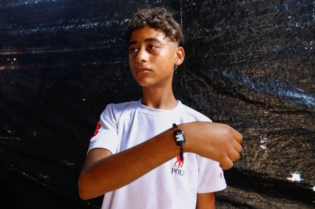 埃爾達巴的兒子亦繫上手環,他正身處加沙南部汗尤尼斯一個庇護所。(路透社)