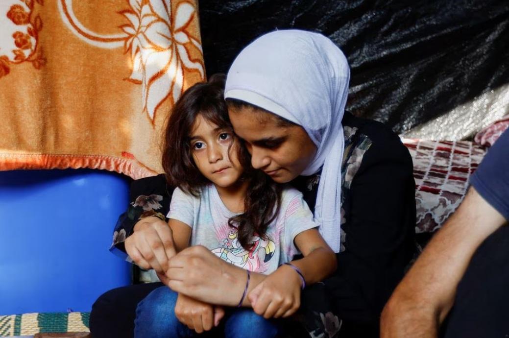 埃爾達巴的兩個女兒戴上用作辨認身份的藍色手環。(路透社)