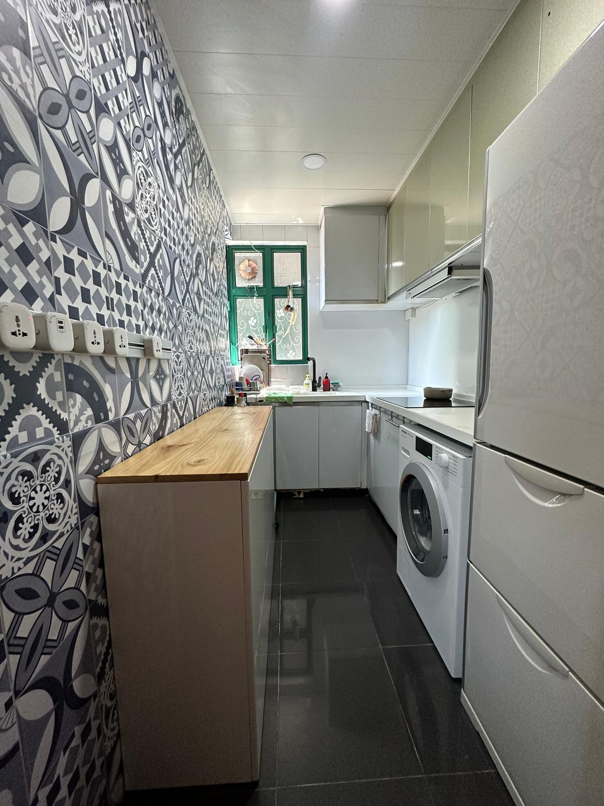 以灰色印花磚牆鋪砌的廚房,雅緻實用,並附有基本電器。