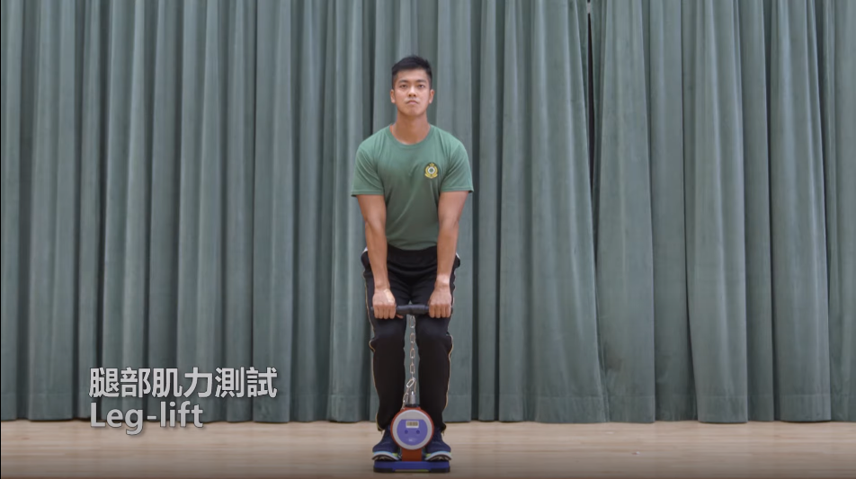 海關督察及關員體能測試 腿部肌力測試須考生雙腳站上儀器與肩膊同寬,臀部向後推,膝蓋微彎下蹲,將掌心面向身體,雙手正握儀器,雙手垂直自然向下,約到大腿位置向上拉。。(海關截圖)
