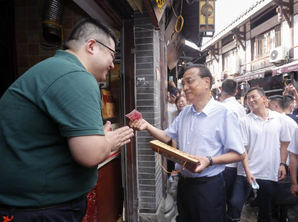 2020年李克強到訪重慶了解災後重建,期間到市區知名景點磁器口,自掏腰包向店家買了三袋麻花,用實際行動支持當地商戶。(資料圖片)