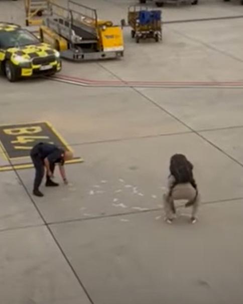 丈夫疑似被激怒企圖衝上前,但被警方制止,他無奈的撿起散落地上的鈔票。(YouTube)