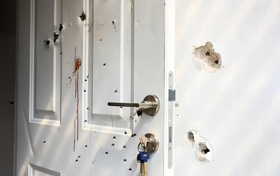 一間房屋的門和牆壁可見彈孔和血跡。(網上圖片)