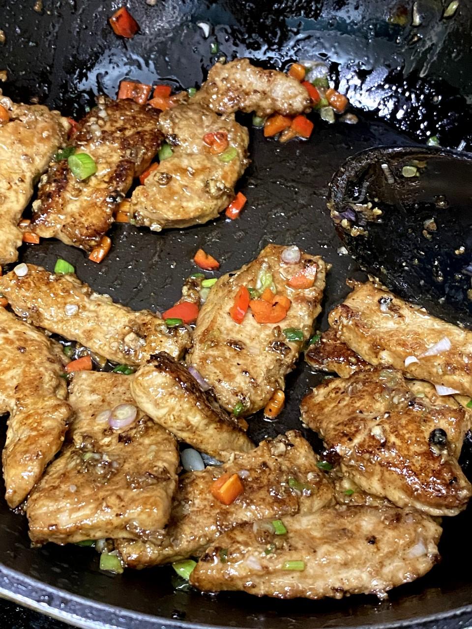 椒鹽豬扒食譜│步驟4 原鑊中細火炸香蒜蓉,加入椒鹽和五香粉同炒,下紅椒粒和葱,豬扒回鑊同炒勻。