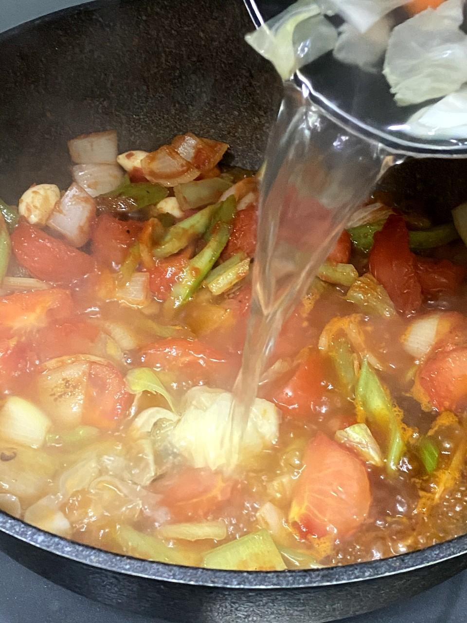 羅宋湯食譜│在湯煲取滾熱蔬菜水1公升,灒入鍋中正在炒的菜中,炒勻,再水連材料倒入湯煲中。