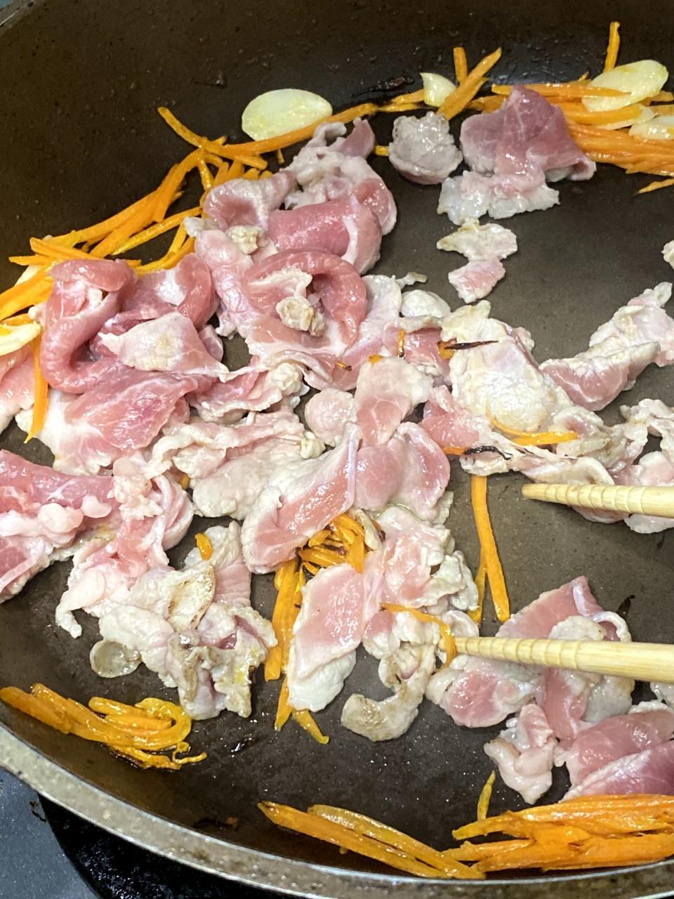 日式炒麵食譜│把豬肉片撥往鑊邊,中間加入油麵,用筷子把麵撥鬆。加入醬汁,炒勻