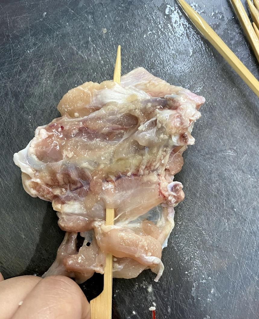 鹽麴燒雞翼食譜│用浸過水的竹籤將雞中翼串起,留意不要穿過雞皮那面。放一架子在焗盤上,將雞翼皮向上放,以預熱至攝氏160度焗8分鐘,反轉再焗4分鐘。掃上油和麻油拌勻的混合油在雞皮那面,灑胡椒鹽,再開200度焗3分鐘。