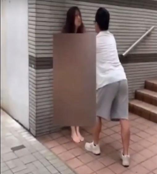 網上熱話|白衣男子將裸女制服在牆邊。(網片截圖)