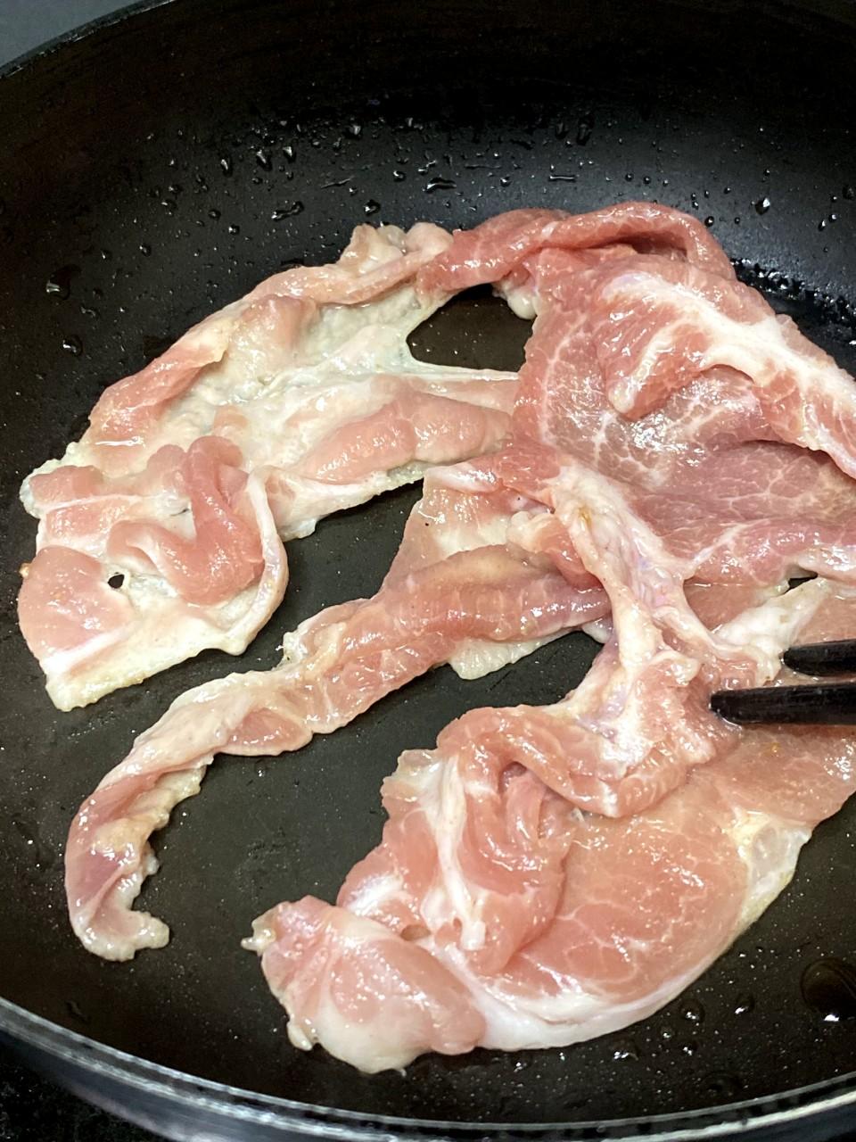 2. 豬肉片加醃料醃10分鐘。燒熱鑊,用少許油煎熟。