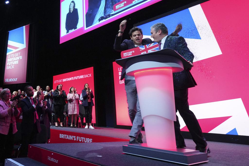 男子衝上台向施紀賢頭上曬金粉。(美聯社)