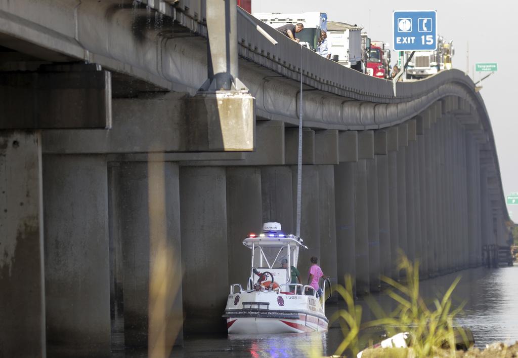 其中一輛汽車墮河,當局派船施救。(美聯社)