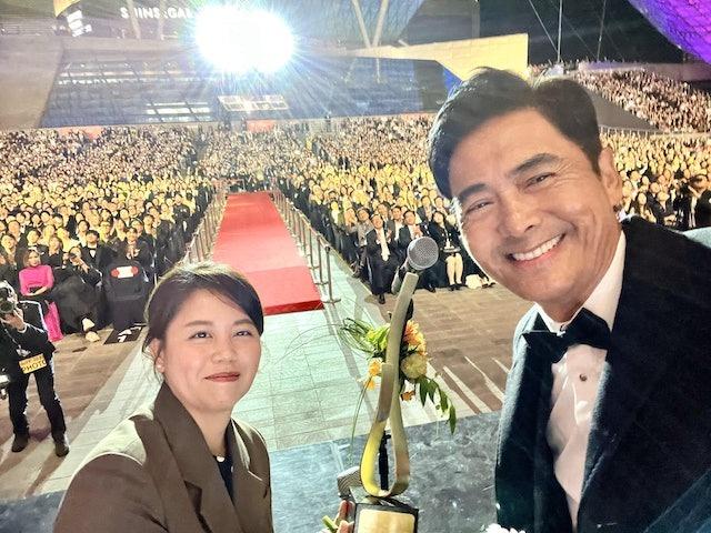 釜山電影節上,周潤發獲頒「亞洲電影人獎」後,親民地和身旁的繙譯及台下來個大合照。(圖片來源:釜山電影節官方相片)